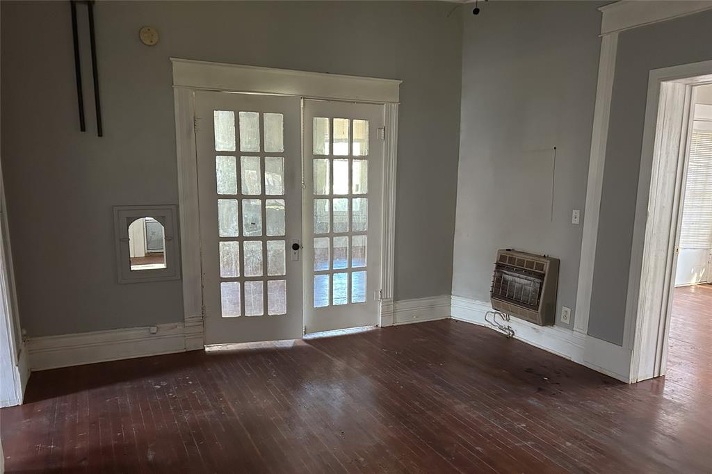701 South Clements Street Gainesville, TX 76240 - Photo 22 of 28 an empty room with wooden floor and windows