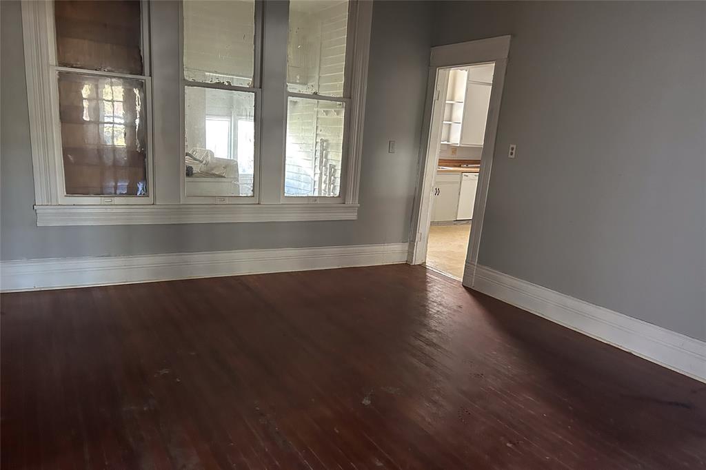 701 South Clements Street Gainesville, TX 76240 - Photo 23 of 28 an empty room with wooden floor and windows