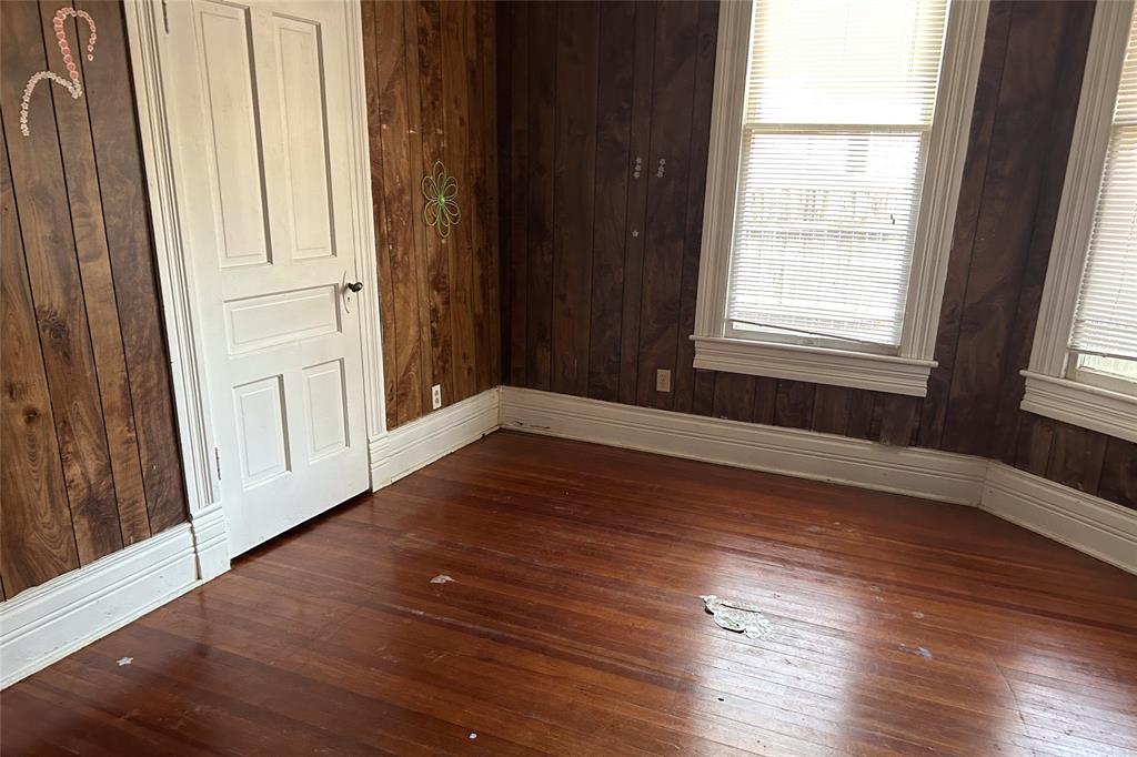 701 South Clements Street Gainesville, TX 76240 - Photo 24 of 28 an empty room with wooden floor and windows