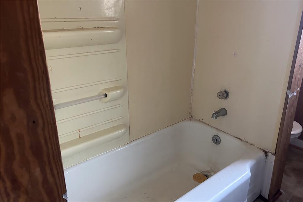 701 South Clements Street Gainesville, TX 76240 - Photo 26 of 28 a bathroom with a bathtub