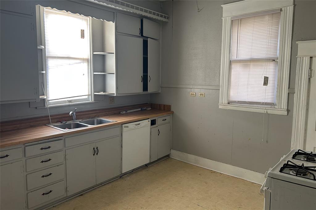 701 South Clements Street Gainesville, TX 76240 - Photo 9 of 28 a kitchen with sink cabinets and window