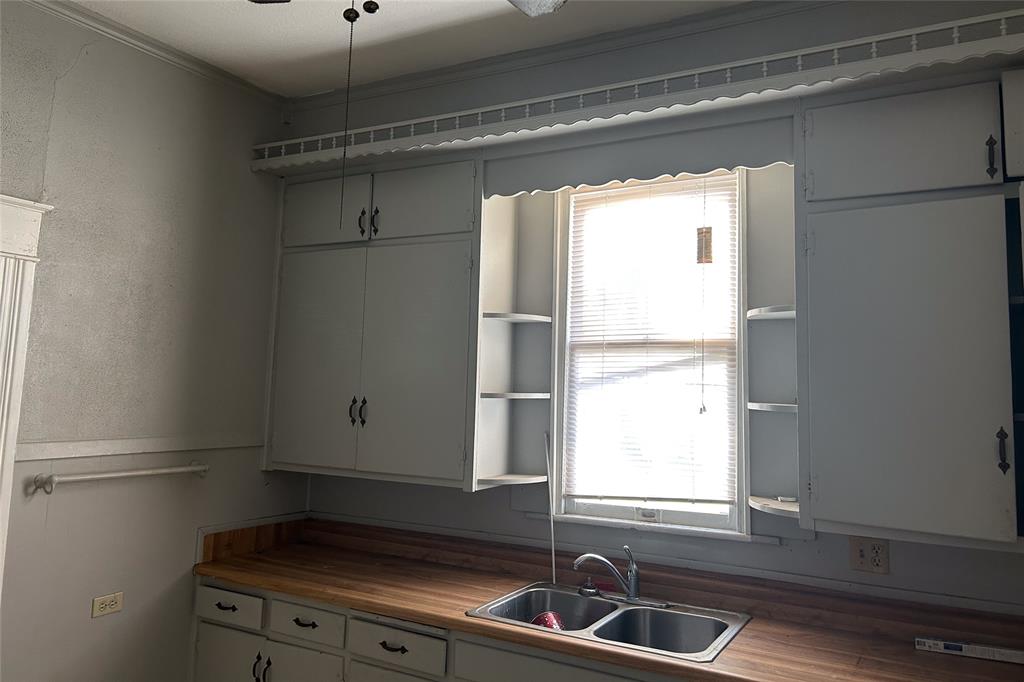701 South Clements Street Gainesville, TX 76240 - Photo 10 of 28 a bathroom with a window sink and cabinets