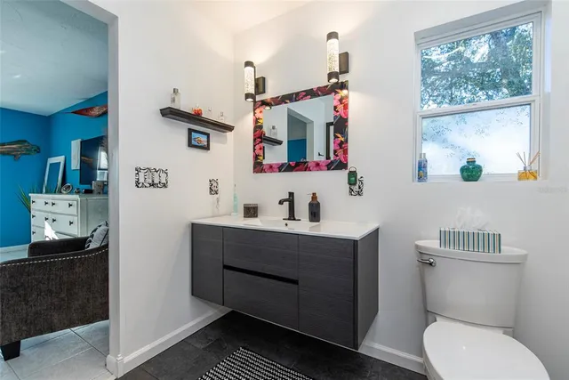 a bathroom with a granite countertop sink a toilet and a mirror