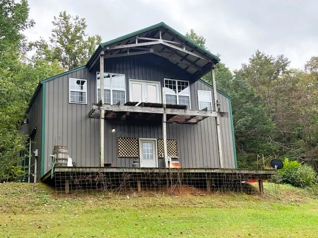a view of a small house with backyard and sitting area