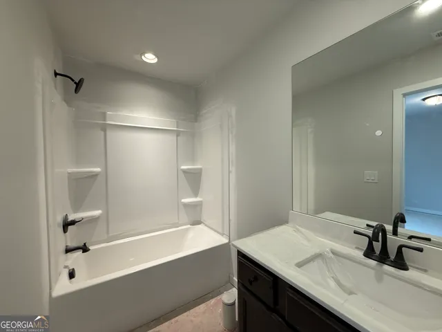 a bathroom with a tub sink and mirror