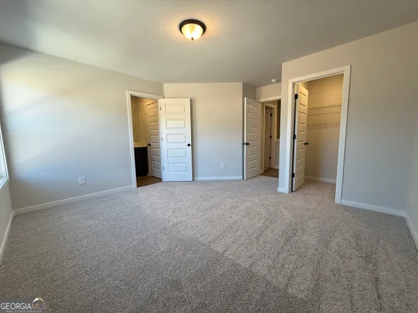 an empty room with closet and natural light