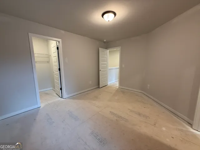 an empty room with closet and mirror