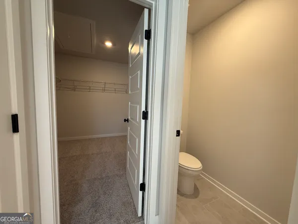 a bathroom with a granite countertop toilet and a sink