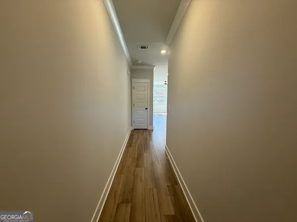 a view of a hallway with wooden floor