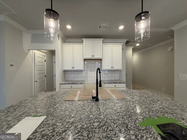 a kitchen with kitchen island a counter top space a sink stainless steel appliances and cabinets