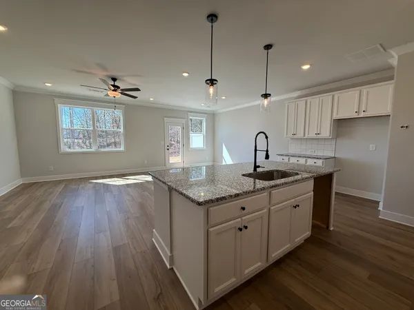 a kitchen with granite countertop a sink and a refrigerator
