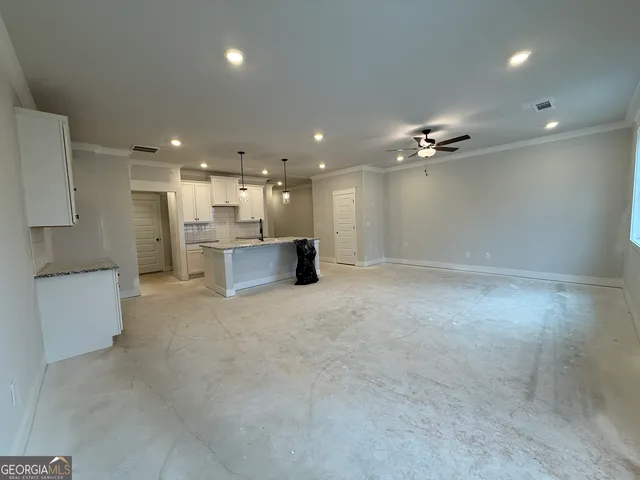 a view of an empty room with a kitchen
