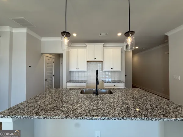 a large kitchen with kitchen island white cabinets and a chandelier