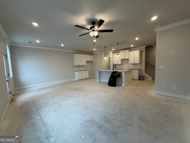 a view of a kitchen with a sink and a stove top oven a refrigerator with wooden floor