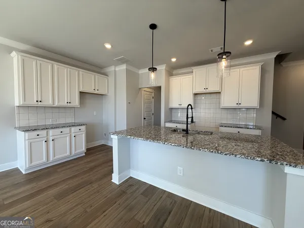 a kitchen with kitchen island granite countertop a sink cabinets and stainless steel appliances
