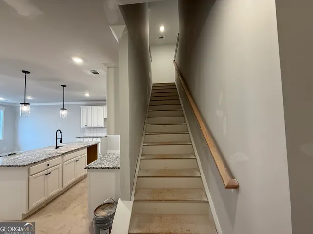 a kitchen with white cabinets and sink