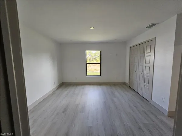 a view of a room with wooden floors and window