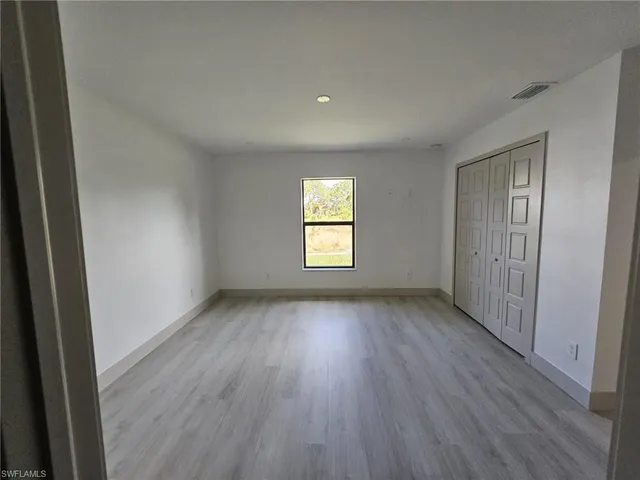 a view of a room with wooden floors and window