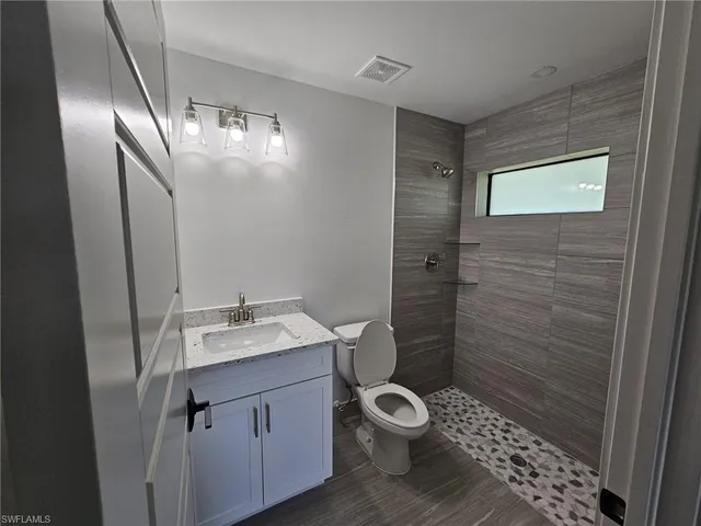 a bathroom with a sink a toilet and shower