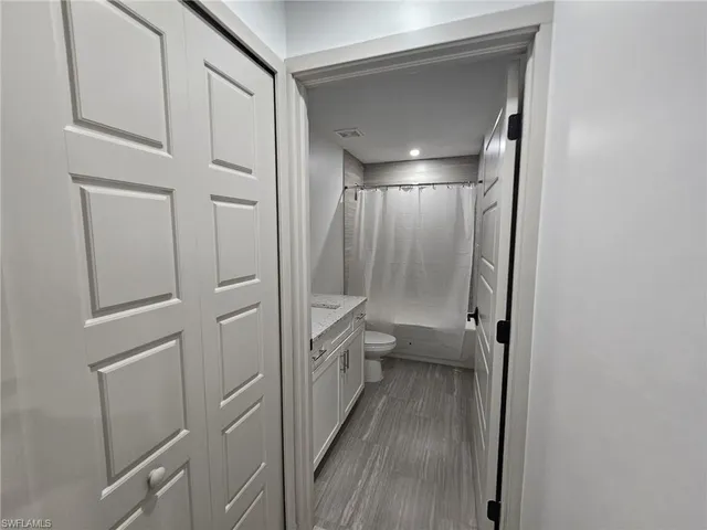 a bathroom with a glass door shower a toilet and a sink