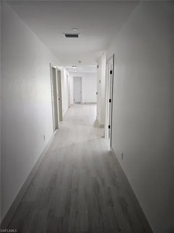 a view of a hallway with wooden floor