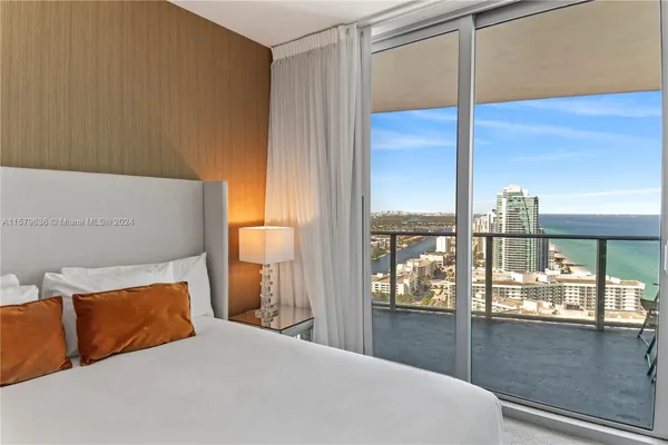 a bedroom with a large window and a balcony