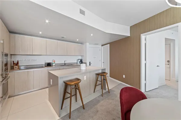 a kitchen with kitchen island a sink a stove a dining table and chairs