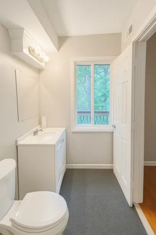 a bathroom with a sink a toilet and window