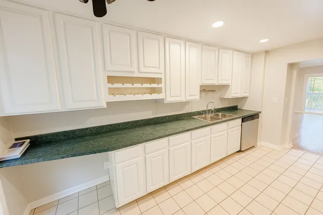 a kitchen with granite countertop white cabinets and white appliances