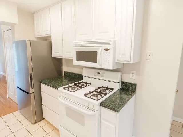 a kitchen with stainless steel appliances granite countertop a stove a refrigerator and a microwave