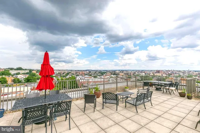 a view of roof deck with table and chairs