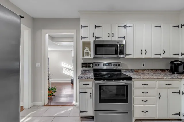 a kitchen with granite countertop a stove and a refrigerator