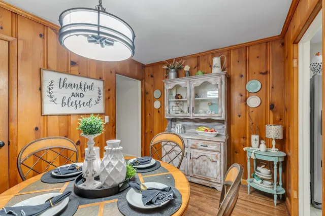 a view of a dining room with furniture a chandelier and wooden floor