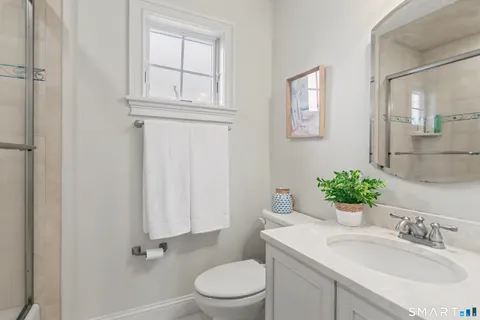 a bathroom with a sink vanity mirror and toilet