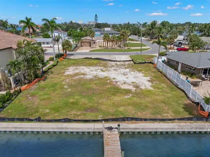 an aerial view of a house with lots of space and lake view in back