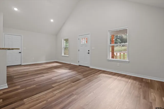 a view of empty room with wooden floor