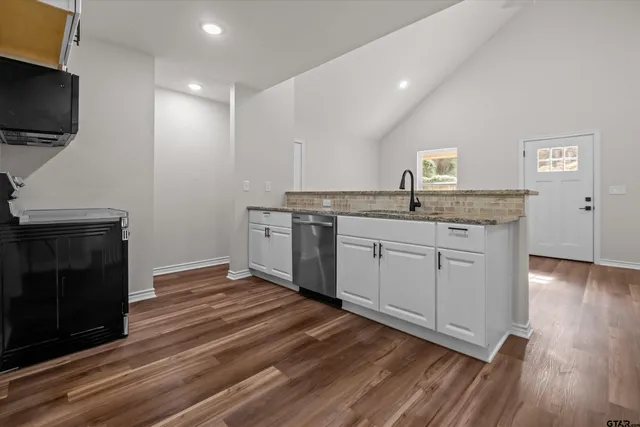 a kitchen with a sink cabinets and wooden floor