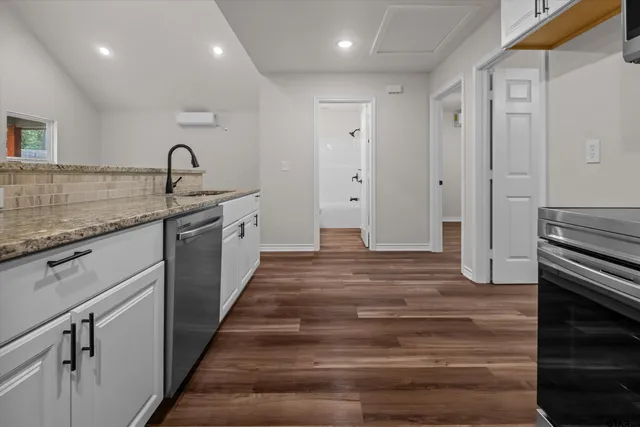 a kitchen with granite countertop a sink and a stove top oven