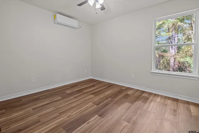 a view of a room with wooden floor and window