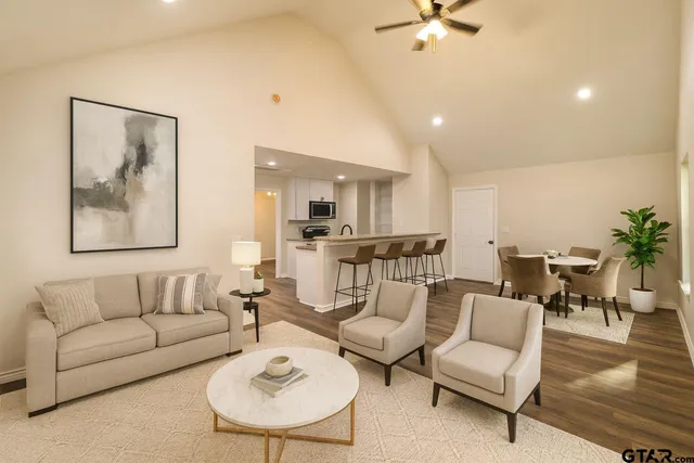 a living room with furniture kitchen view and a potted plant