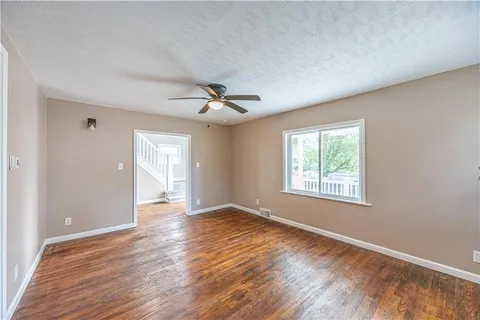 a view of an empty room with a fireplace and a window