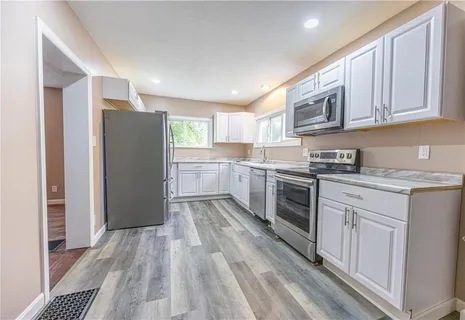 a kitchen with stainless steel appliances granite countertop a refrigerator and a stove top oven