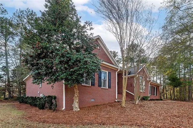 a front view of a house with a yard and trees