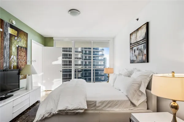 a living room with furniture a flat screen tv and a window