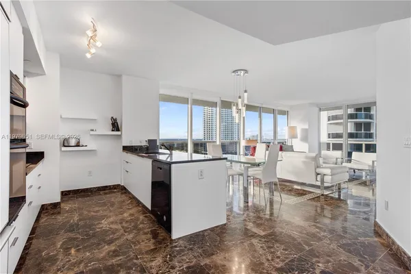 a kitchen with white cabinets and wooden floor