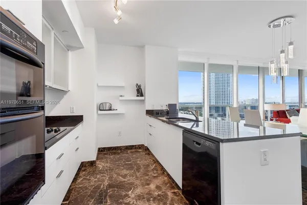 a kitchen with granite countertop a sink stove and cabinets