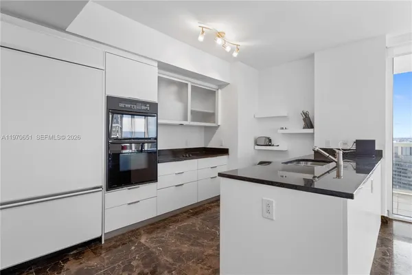 a kitchen with granite countertop white cabinets and white appliances