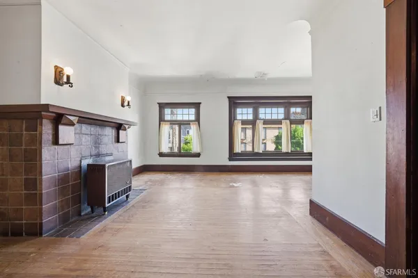 a view of an empty room with a fireplace and a window