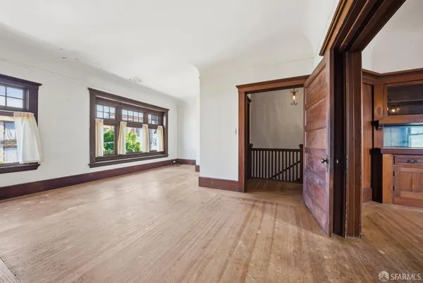 a view of hallway with a large window and wooden floor