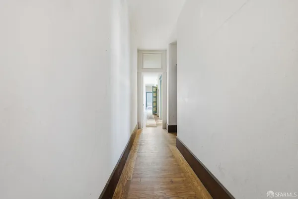 a view of a hallway with wooden floor